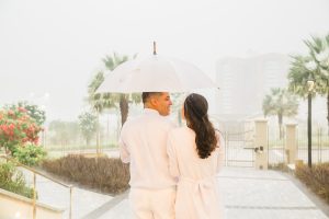 noivos se entre olhando apaixonados segurando guarda chuva branco sob muita chuva no templo de fortaleza